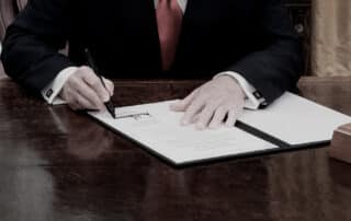 Image of Donald Trump signing a document