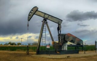 Oil Well in Colorado in foreground, moody grey sky in the background.