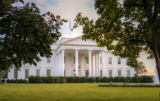 White house front facade at sunset with a vignette of foliage in the foreground