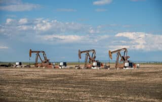 Three pumpjacks in an oil field