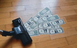 A vacuum cleaner sucking up 1 dollar bills