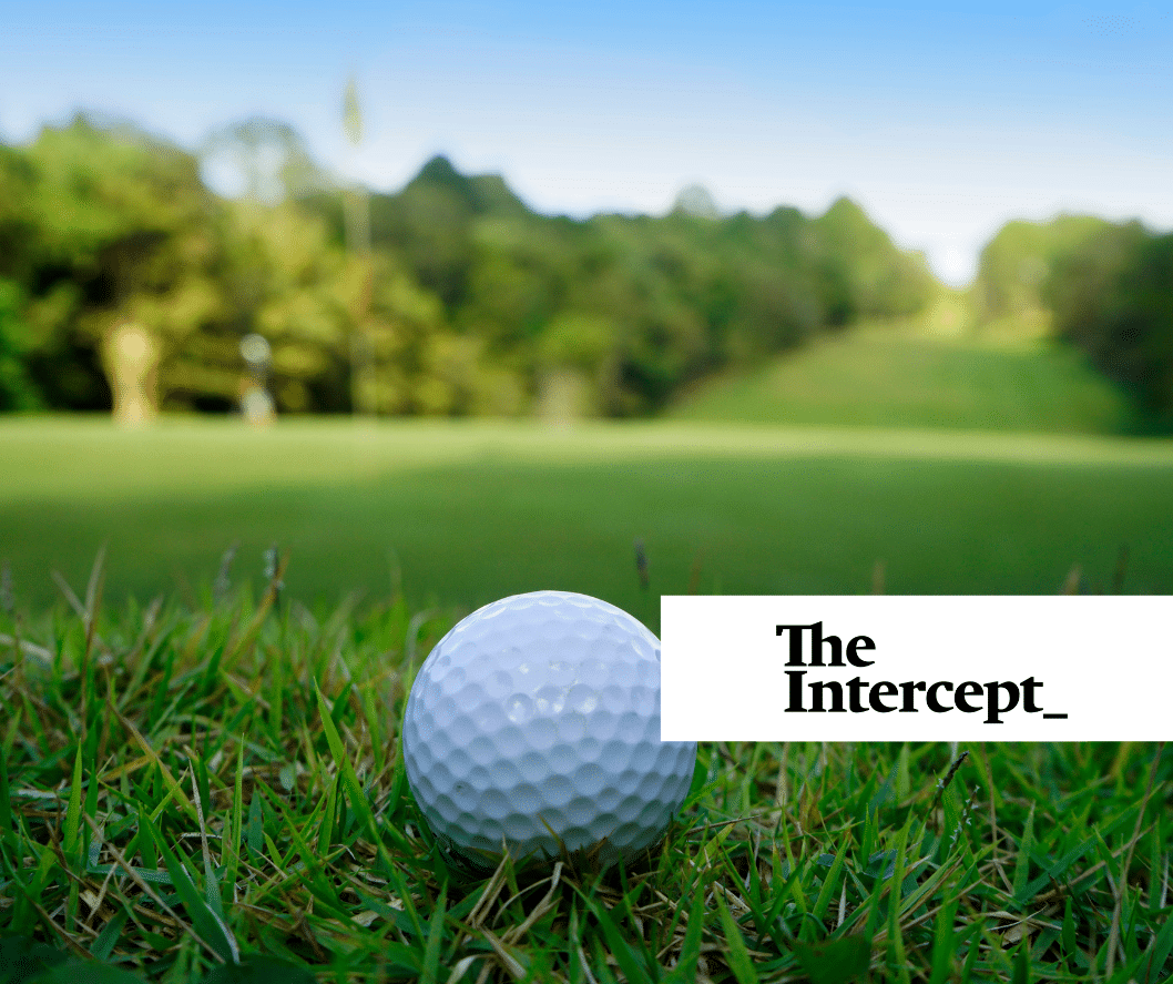 A golf ball in the foreground and a gold course in the back